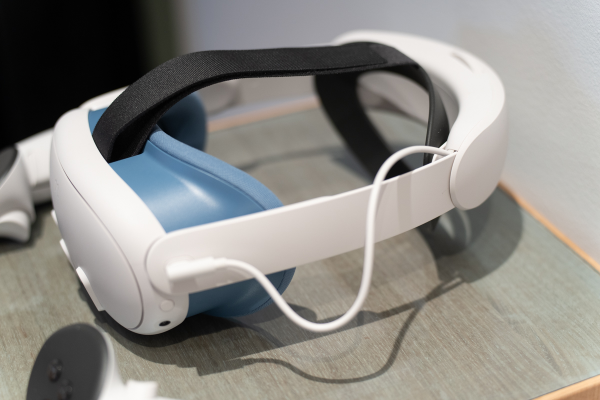 Meta Quest 3 mixed reality headset resting on a surface with a blue pad