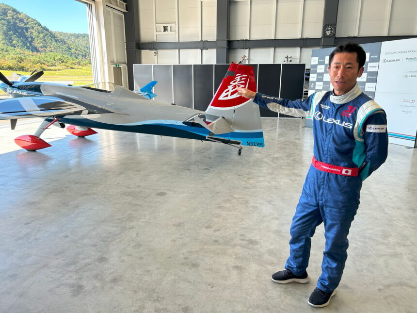 Pilot Yoshi Moriya points to his plane in the hangar at Fukushima Air Park